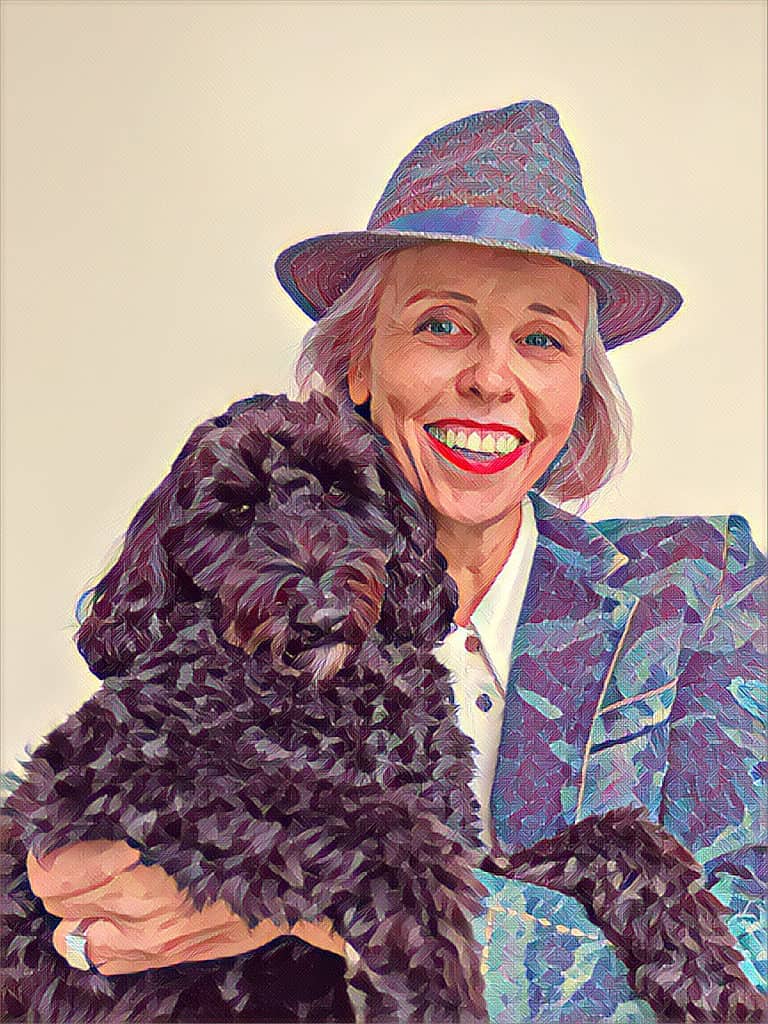 Anne met hoed op en met assistentiehond Sophie in armen